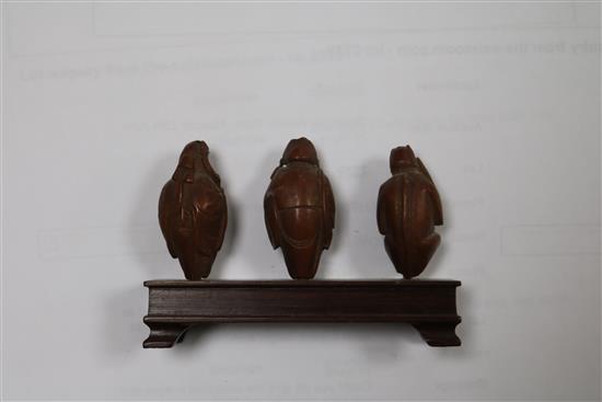 A set of six Chinese peach stones carved as immortals and a monkey, rosewood stands, each approx. height 4cm